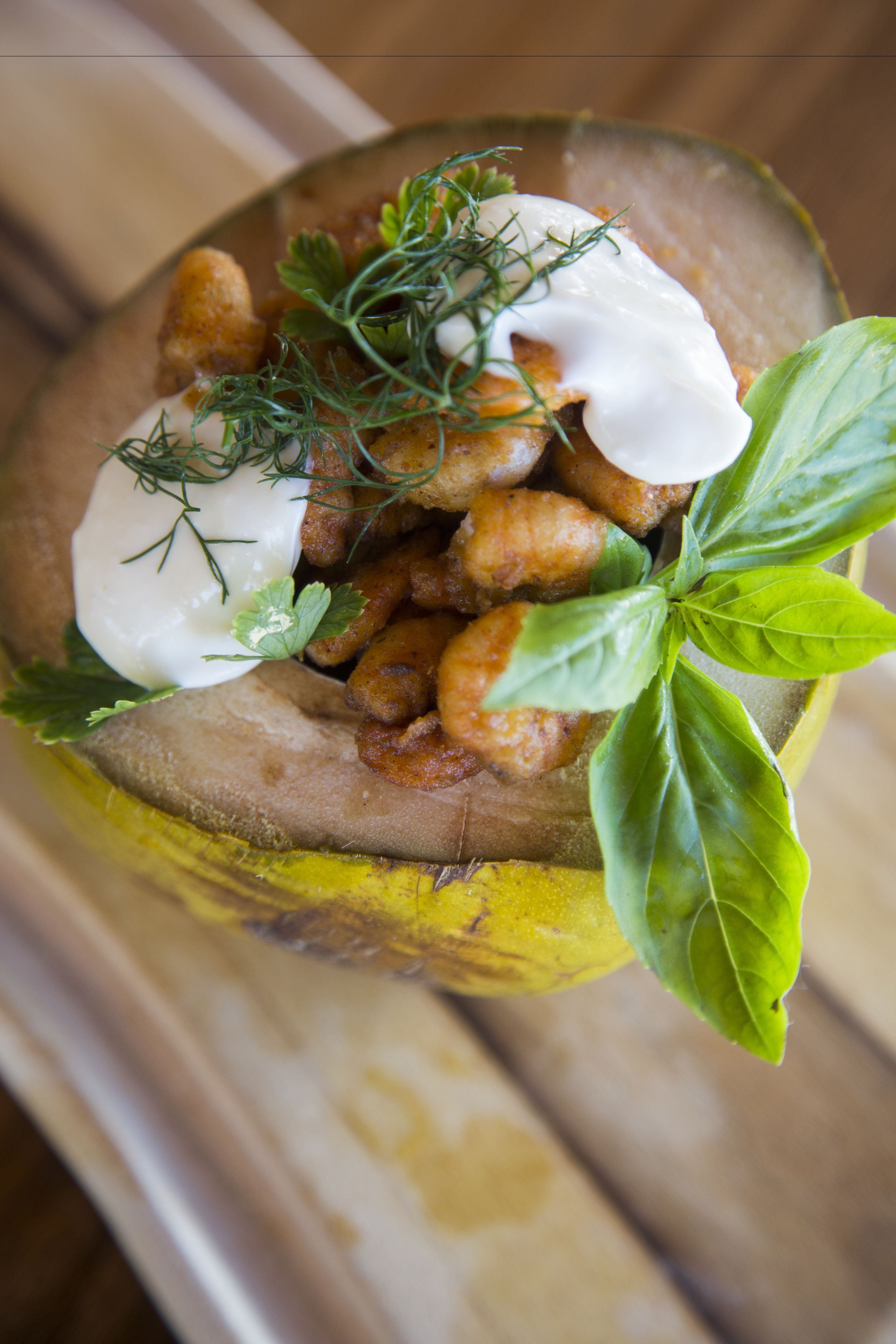 A dish with a creamy sauce, garnished with herbs and a basil leaf.