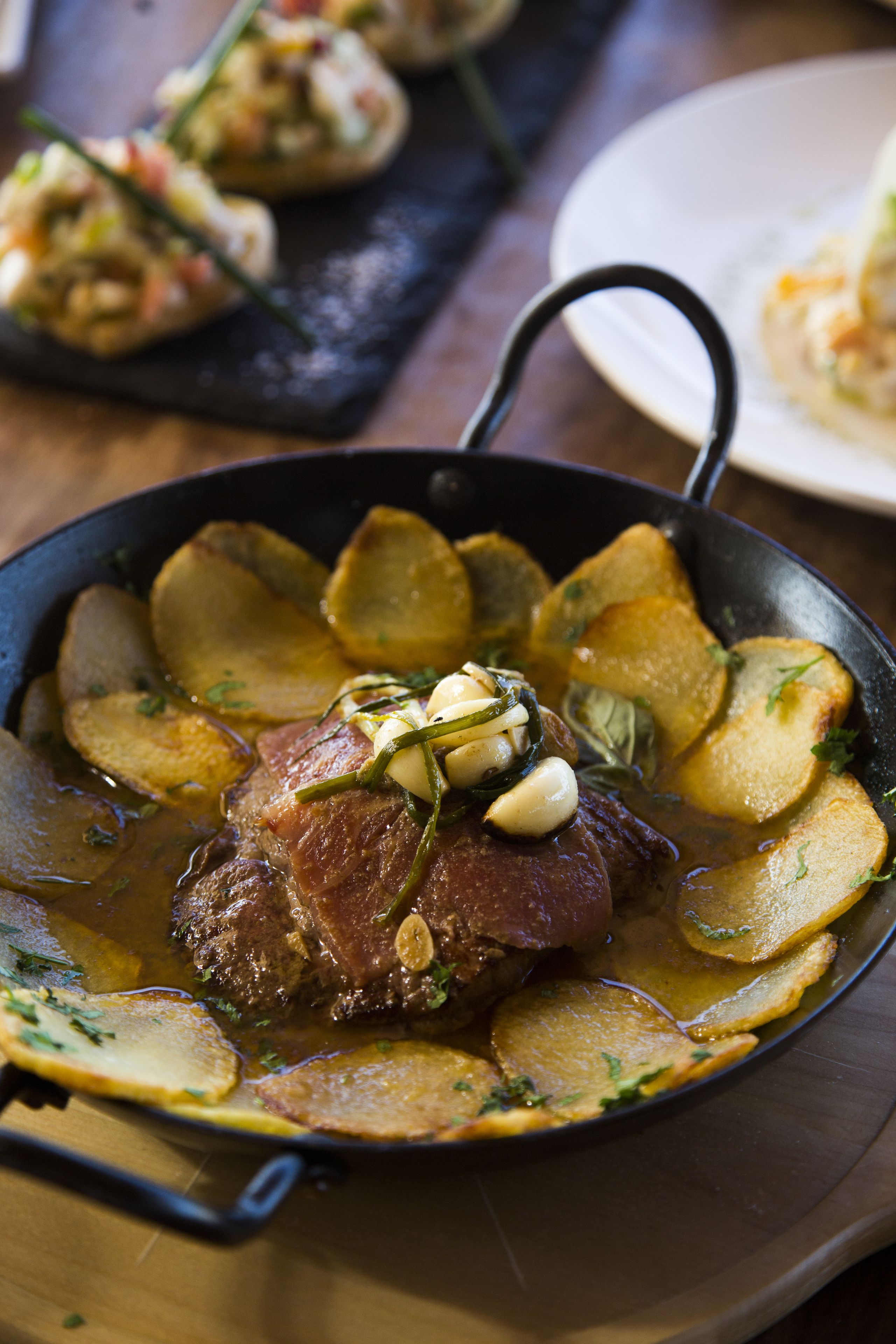 Una sartén con un bistec y papas.