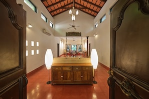 Ein geräumiges Zimmer mit einem großen Holzkasten, einem Deckenventilator und einer Chandelier.