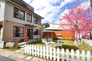A two-story building with a brick facade, a white picket fence, and a small patio area with outdoor furniture. - Moonlake B&B-58 (Yuchi)