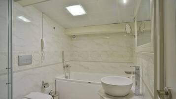 A bathroom with a bathtub, toilet, and sink.