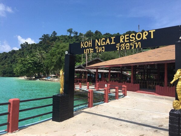 A sign for Koh Ngai Resort with a view of the beach and ocean. - Koh Ngai Resort Trang (Ko Lanta)