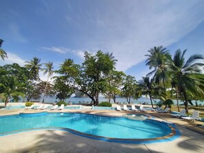 A swimming pool with lounge chairs and palm trees. - Koh Ngai Resort Trang (Ko Lanta)