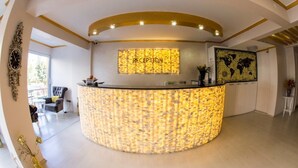 A reception area with a curved counter, a world map, and a clock. - Bilge Suite Hotel (Corum)