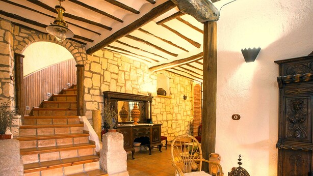 A rustic interior with stone walls, wooden staircase, and traditional furnishings. - Molino de Morillas (Galera)