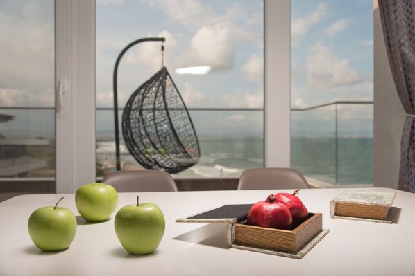 Una mesa con tres manzanas verdes, una granada y dos libros.