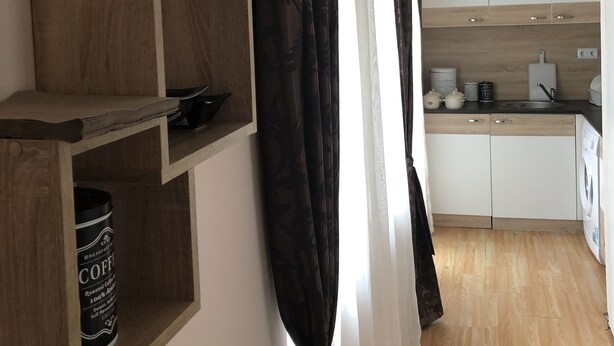 Een moderne keuken met houten kastjes, een spoelbak en een koffieapparaat.