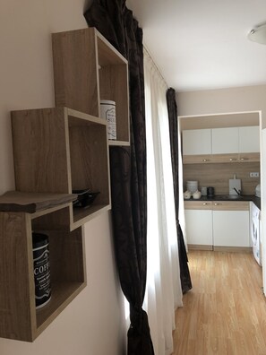 A modern kitchen with wooden cabinets, a sink, and a coffee machine. - Palace Deluxe Hotel (Pomorie)
