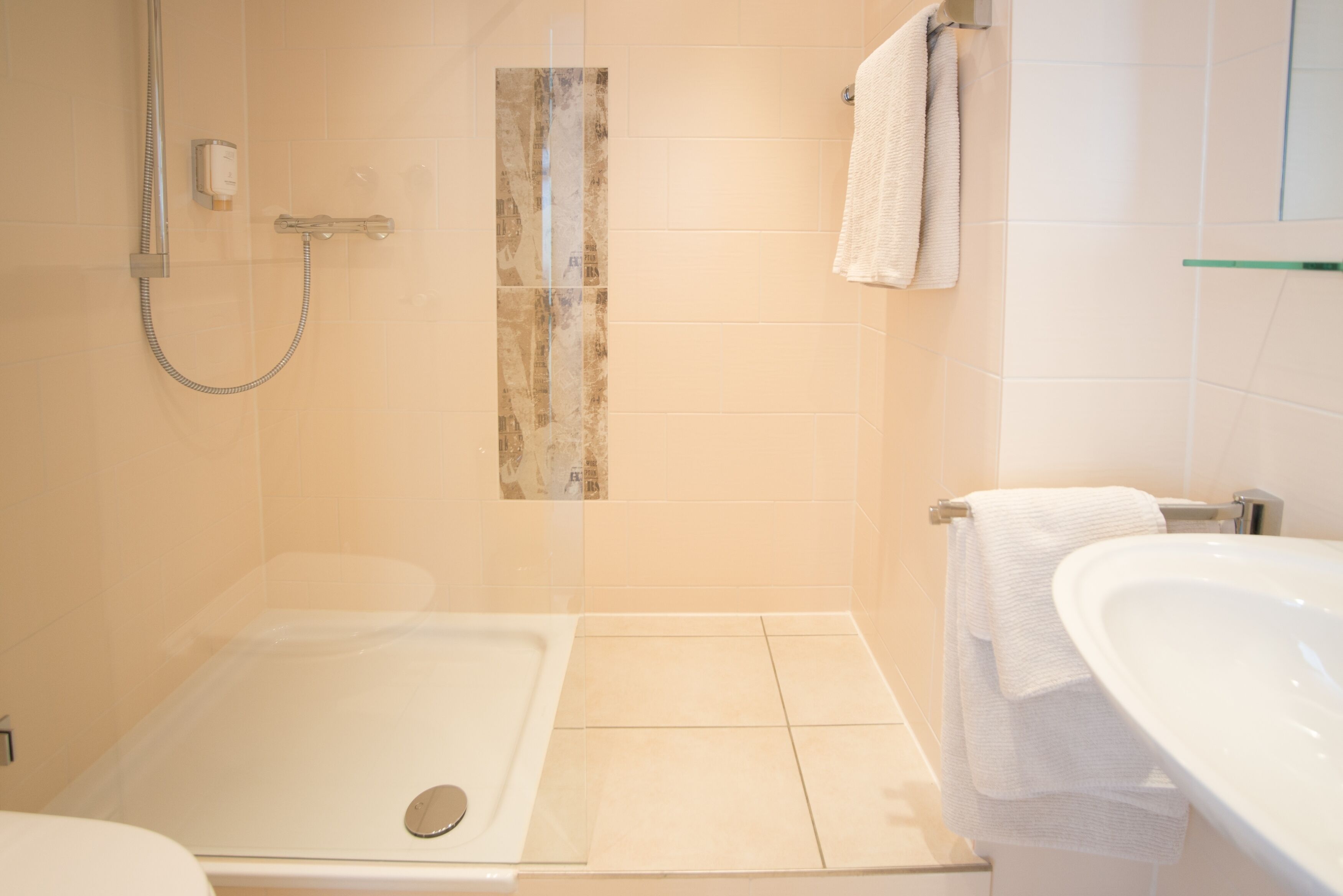 Un baño moderno con ducha, bañera y lavamanos.
