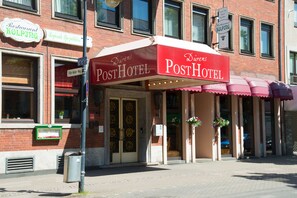 Un hotel con un toldo rojo y un letrero que dice 'PostHotel'.