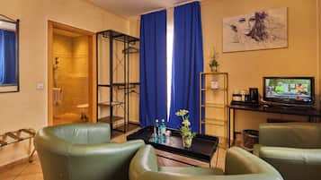 Junior Suite | Woonruimte | Een 22-inch flatscreentelevisie met satellietzenders en een televisie