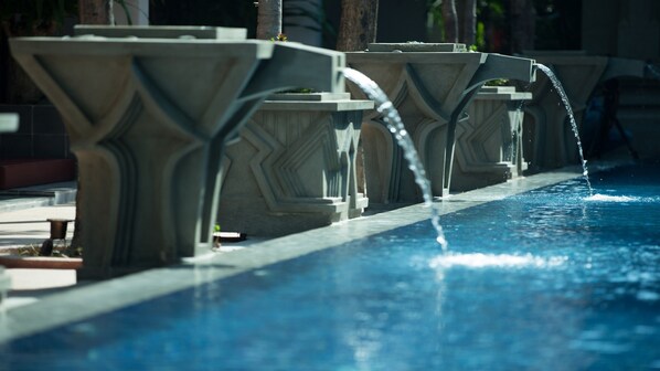 A pool with multiple water features, including a central water jet and two side jets.