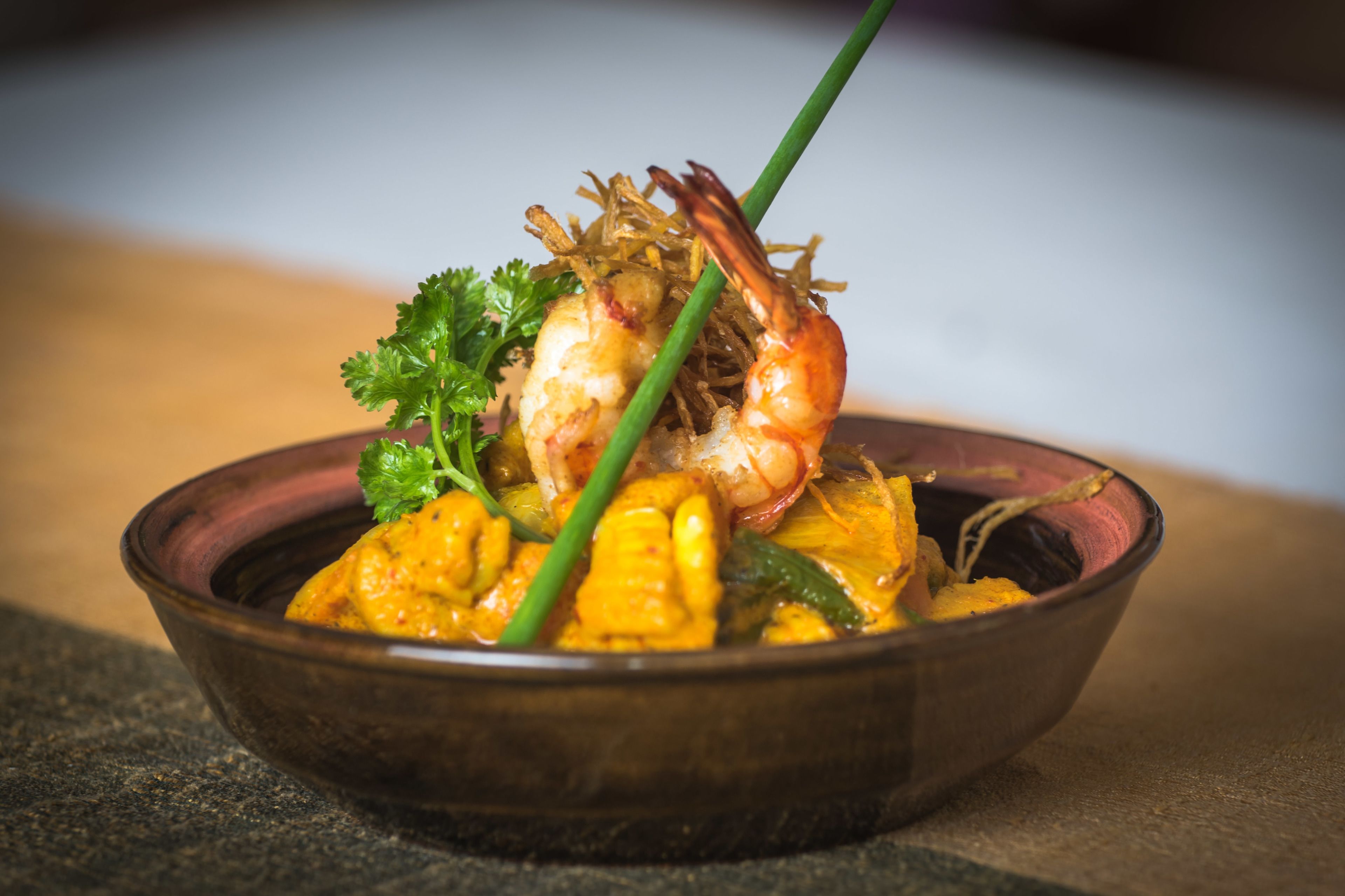 A bowl of food with shrimp and vegetables.