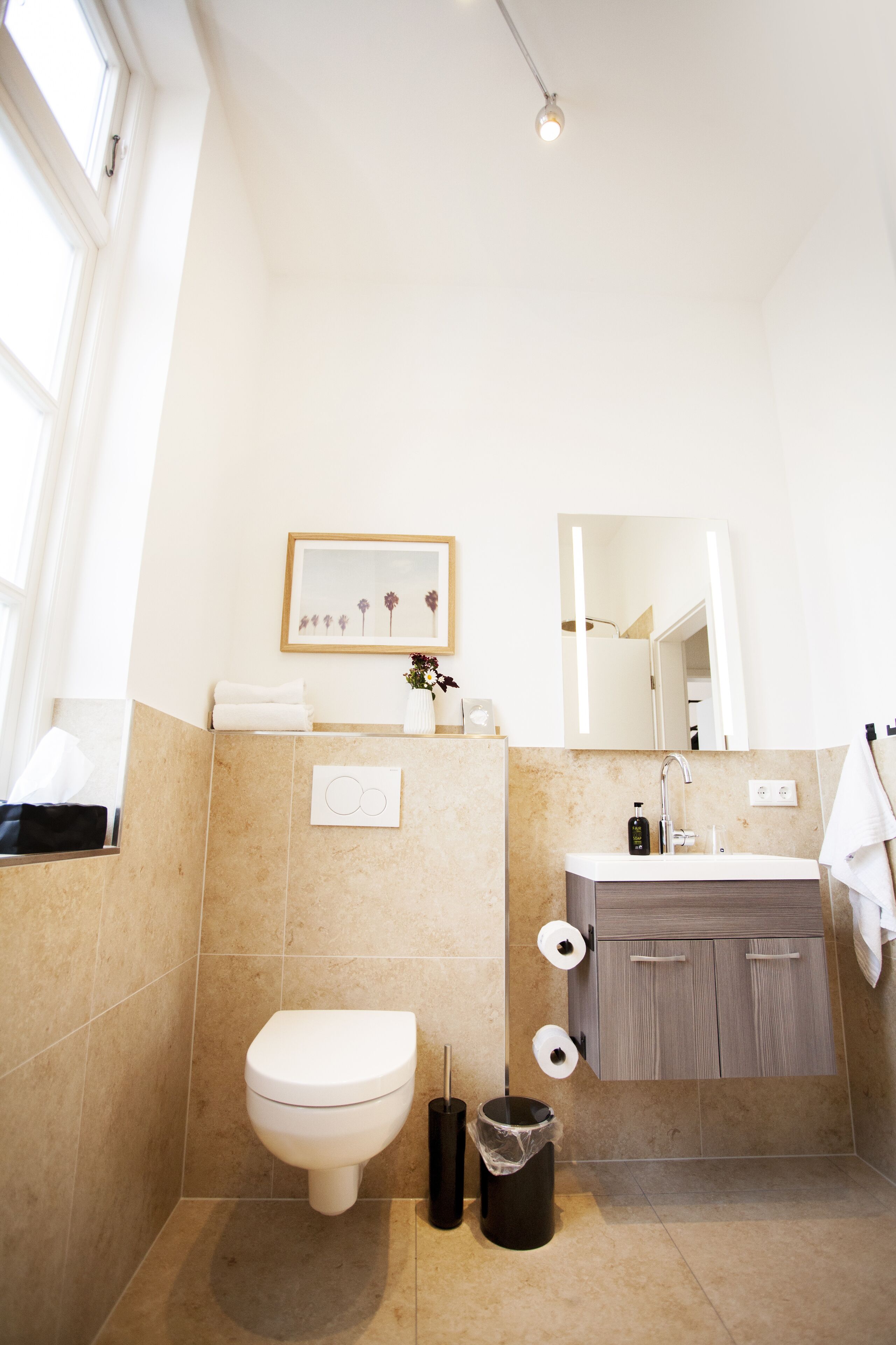 Un baño moderno con inodoro, lavamanos y espejo.