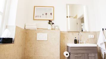 Un baño moderno con inodoro, lavamanos y espejo.