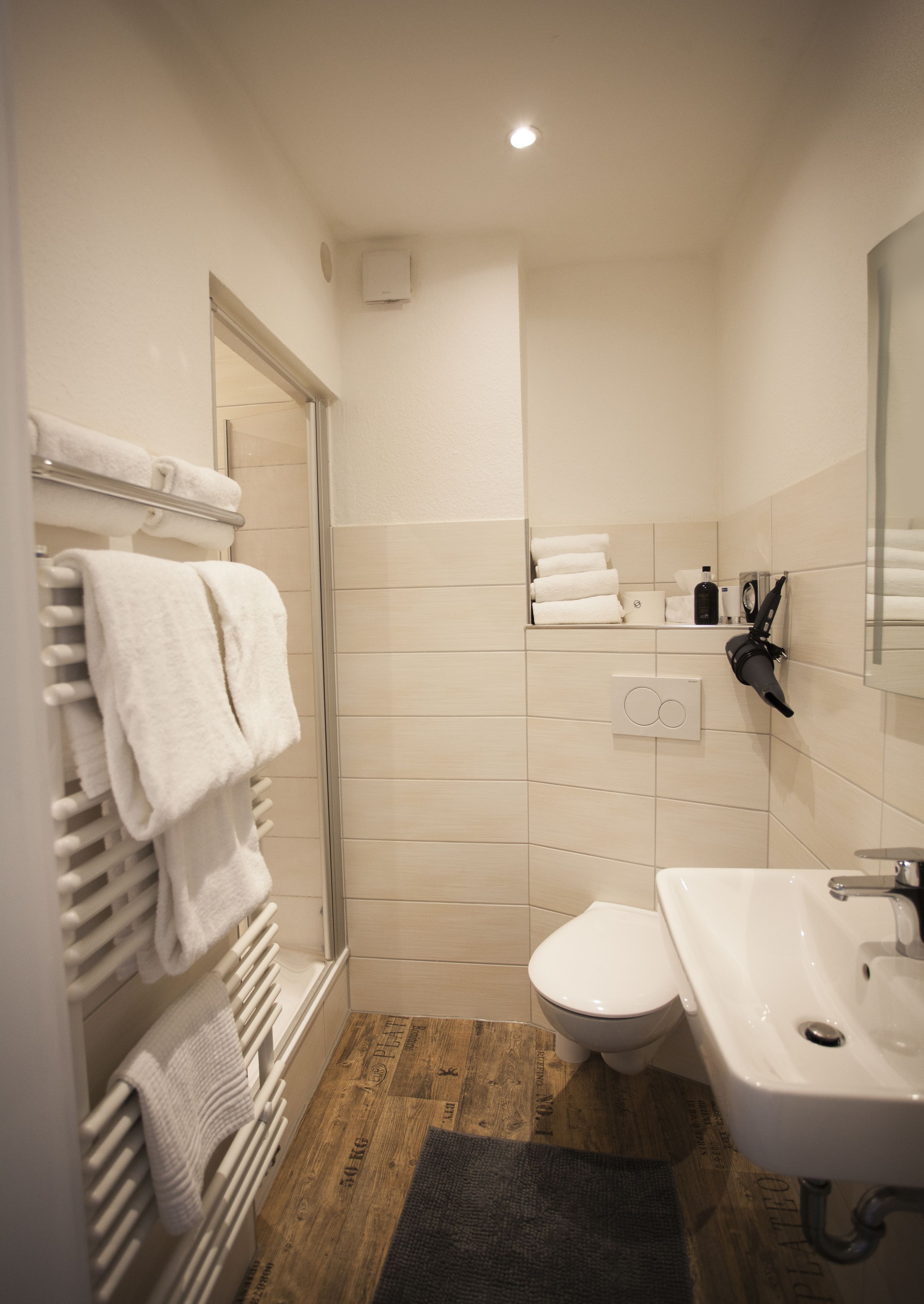Een moderne badkamer met douche, toilet en wastafel.