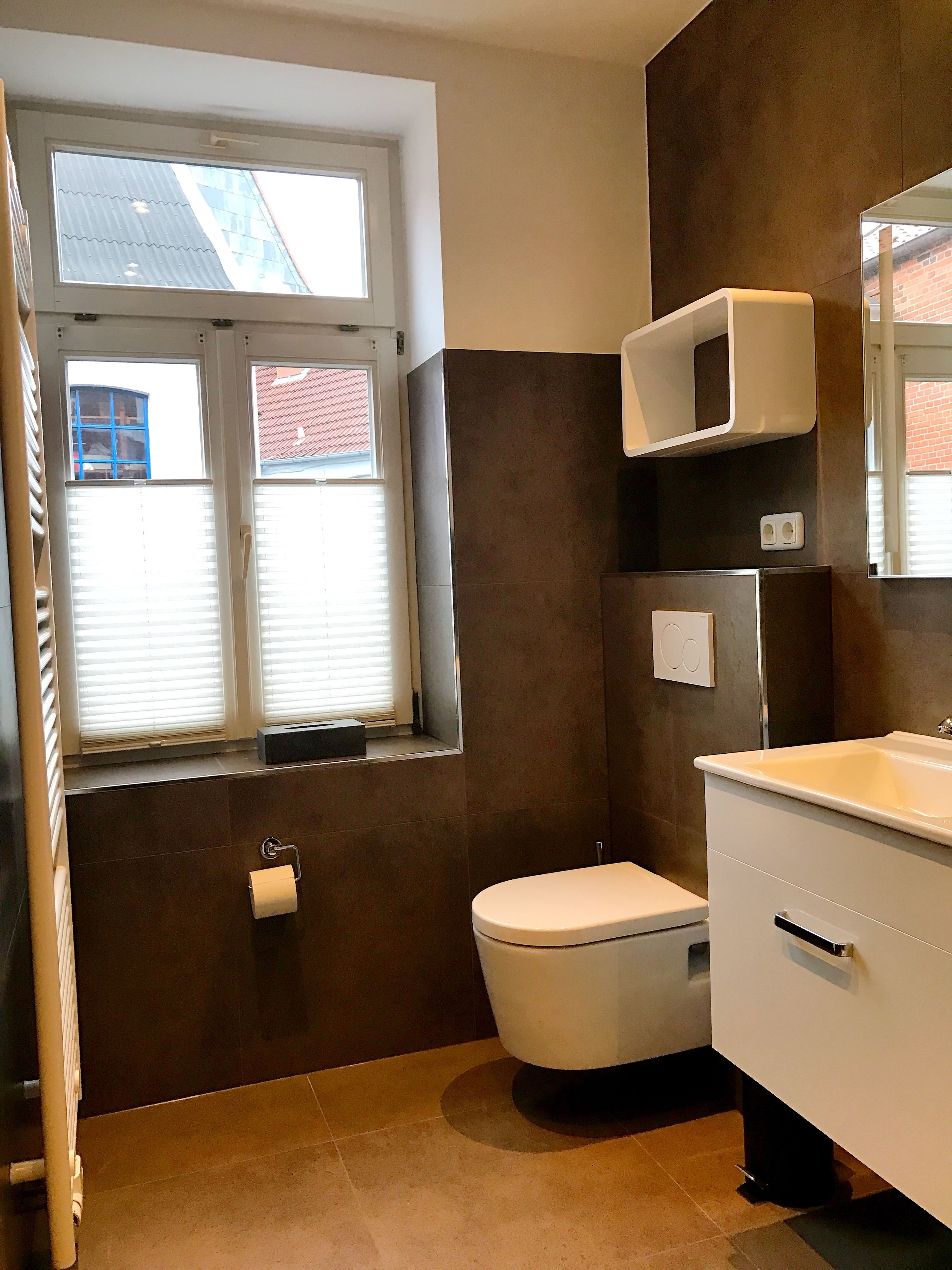 Un baño con inodoro, lavamanos y ventana.