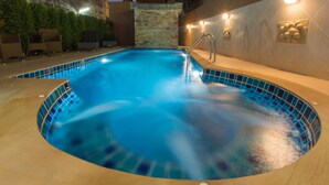 Una piscina al aire libre, sillones reclinables de piscina