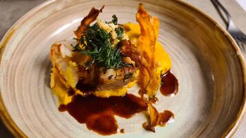 Une assiette contenant un plat composé d’une portion de viande, de légumes et d’une sauce.
