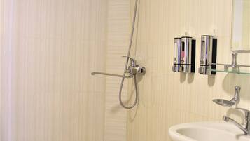 Un bany modern amb banyera autònoma, un lavabo i una dutxa.