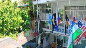 En bygning med flere etager, altaner, plantekasser og flag.