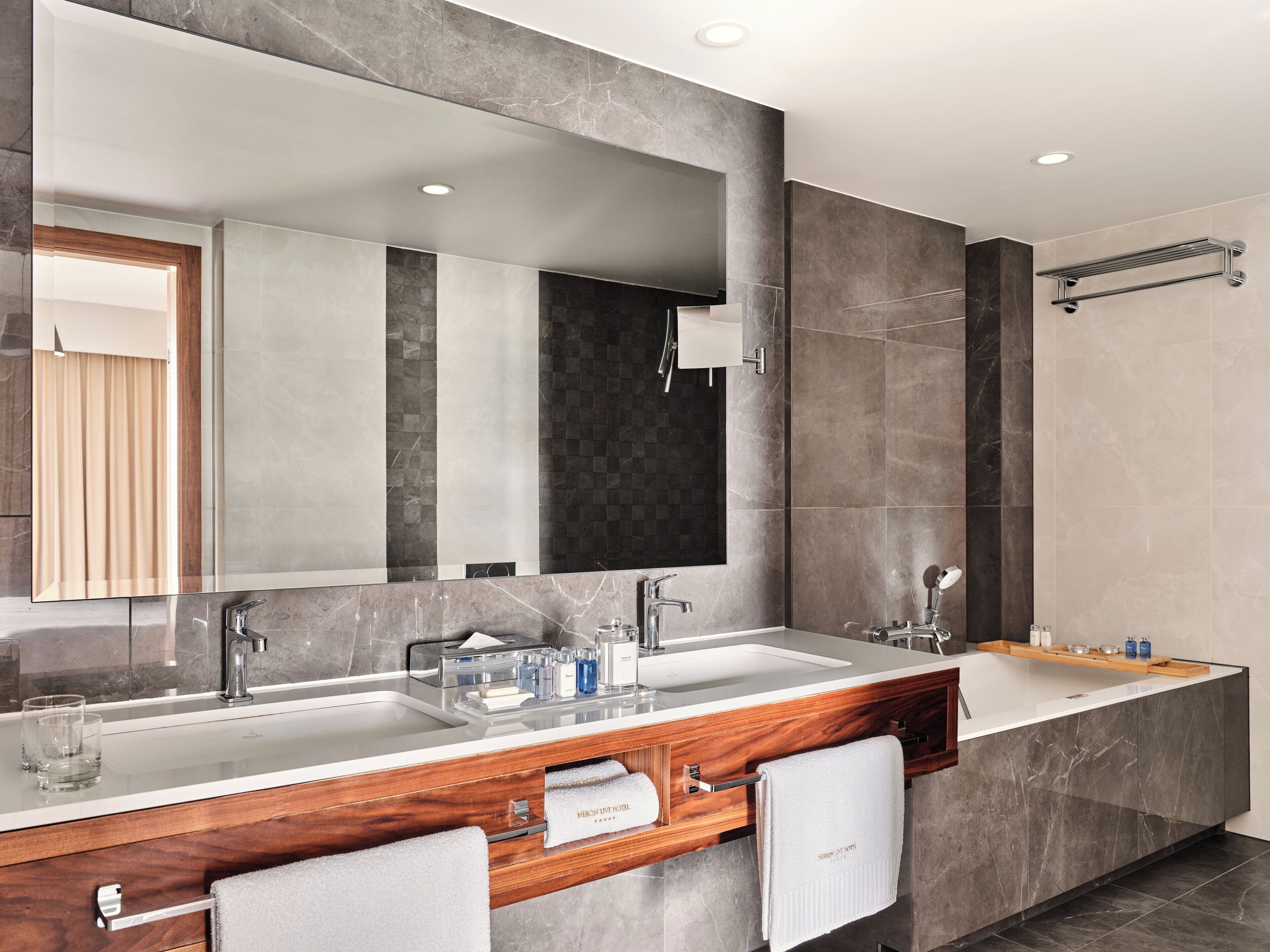 Un baño moderno con dos lavamanos, un espejo grande y una zona de ducha.