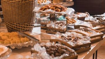 Ein Buffet mit verschiedenen Speisen, präsentiert auf Tabletts und in Körben.