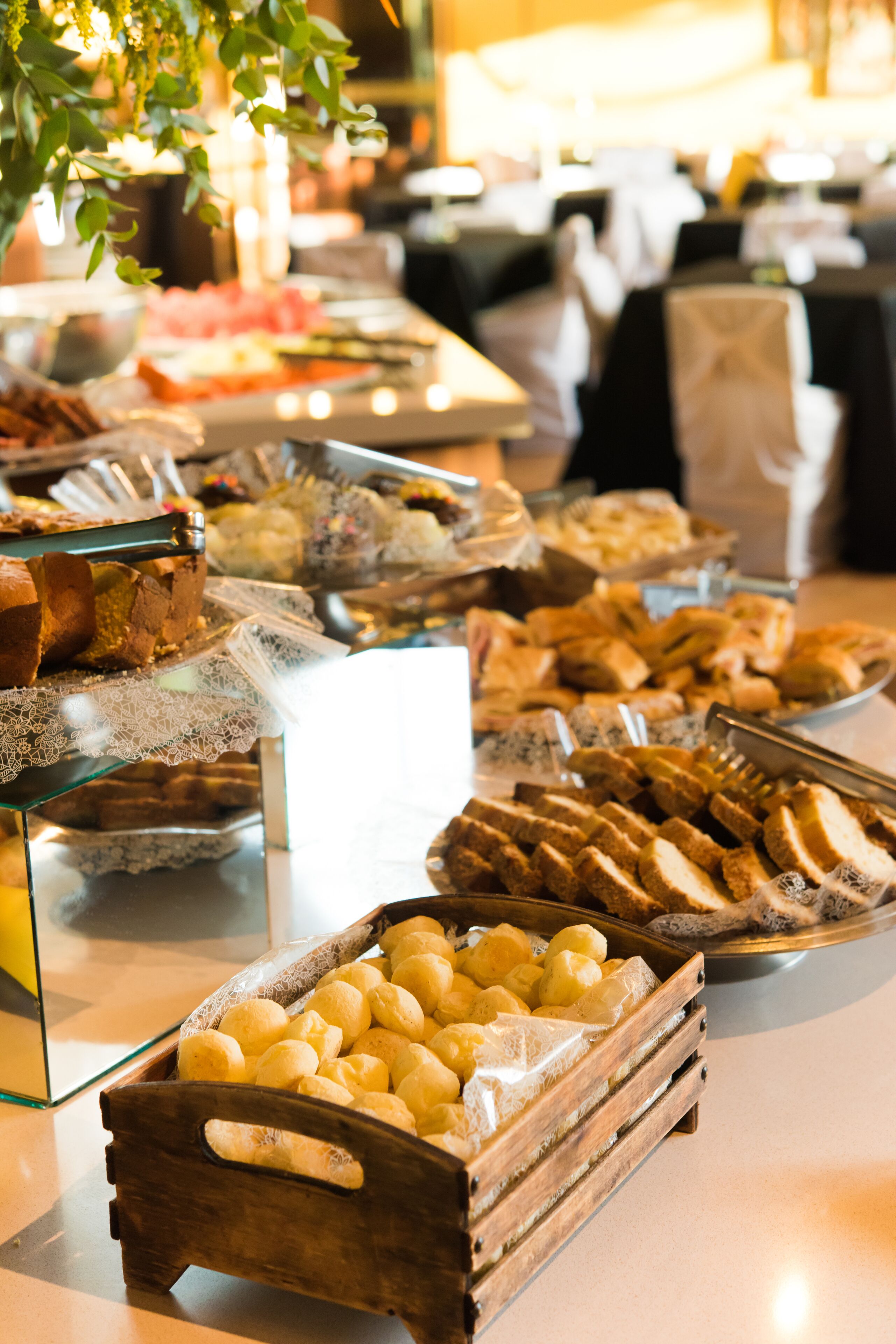A buffet with various food items including bread, pastries, and cheese.