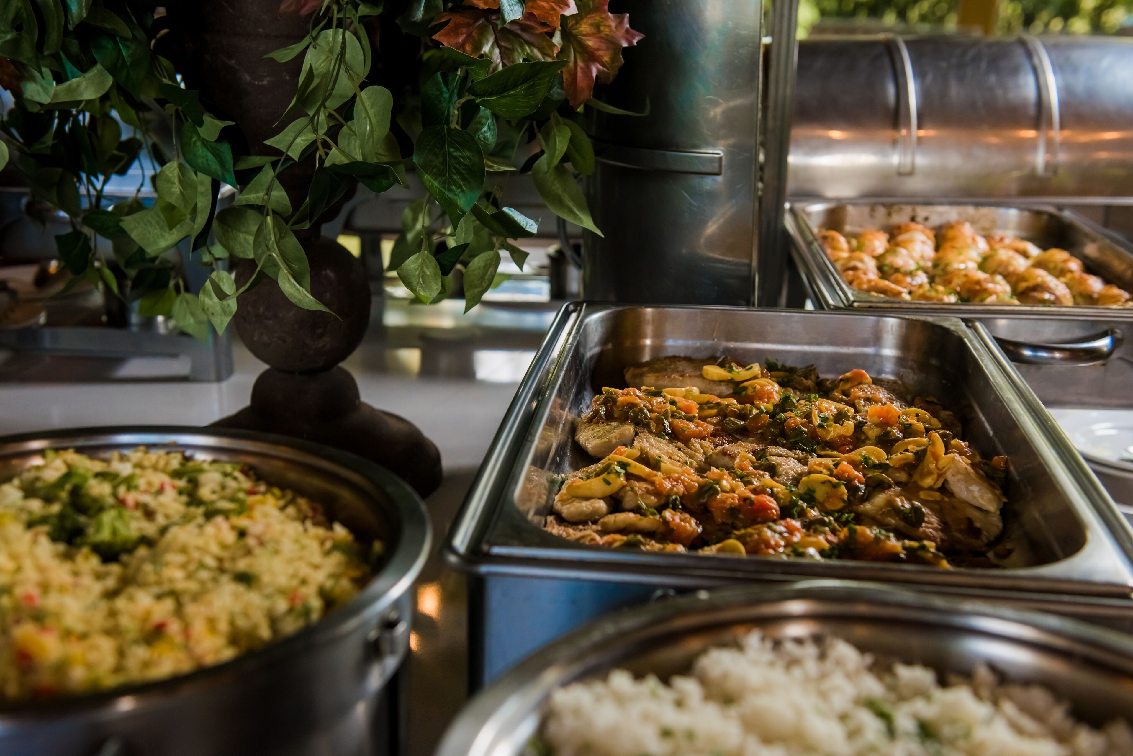 Un bufé con diversos platos, incluyendo arroz, pollo y verduras.