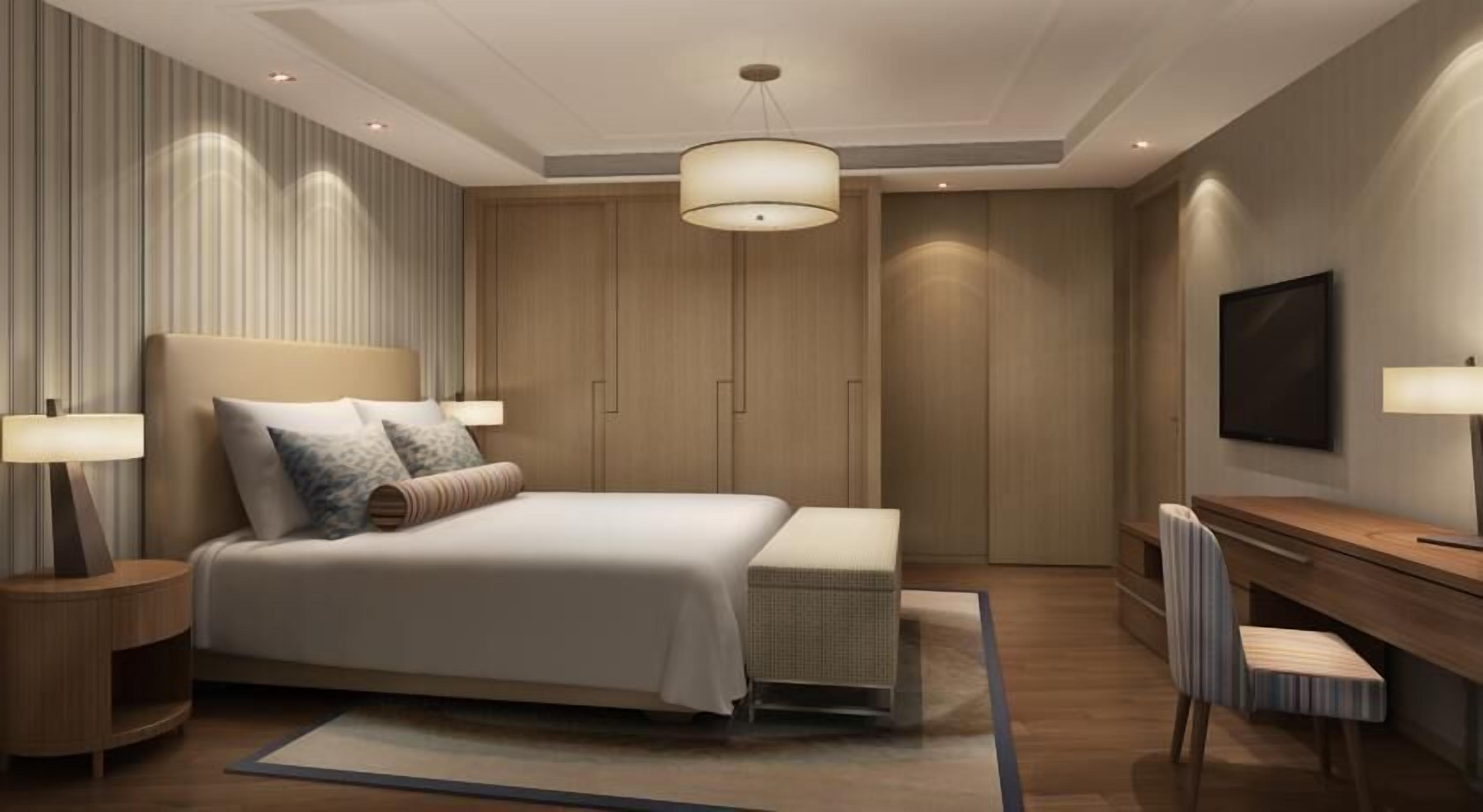 Una camera da letto moderna con un letto grande, lampade sui comodini, una TV e una scrivania in legno.