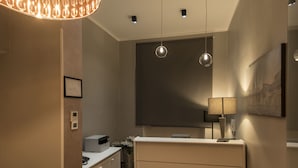 A modern bathroom with a marble floor, a white vanity, a large mirror, and a geometric pendant light. - Fabio Massimo Guest House (Rome)