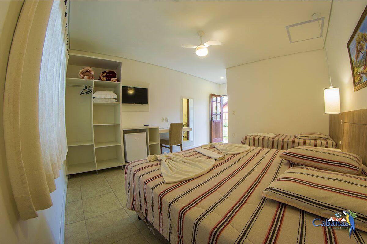 A bedroom with a bed, a desk, and a wardrobe.