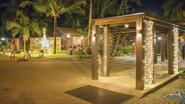 A covered outdoor area with a wooden structure, palm trees, and a sign reading "Cabanas." - Cabanas Termas Hotel (Gravatal)