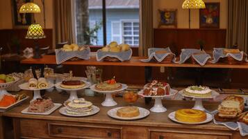 Uma mesa de buffet com diversos doces e cestas de pão.