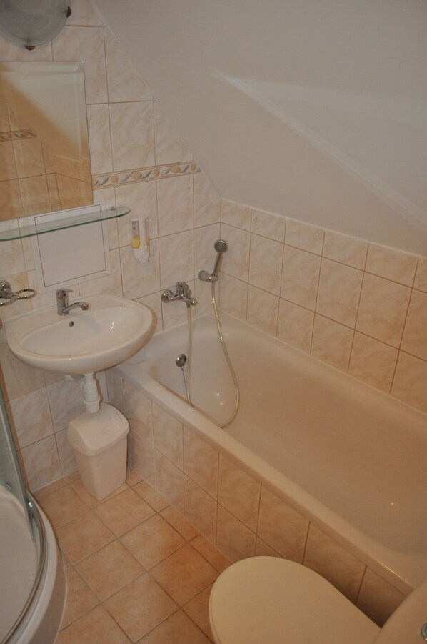 A bathroom with a sink, toilet, and bathtub. - Penzión AQUA (Trencianske Teplice)