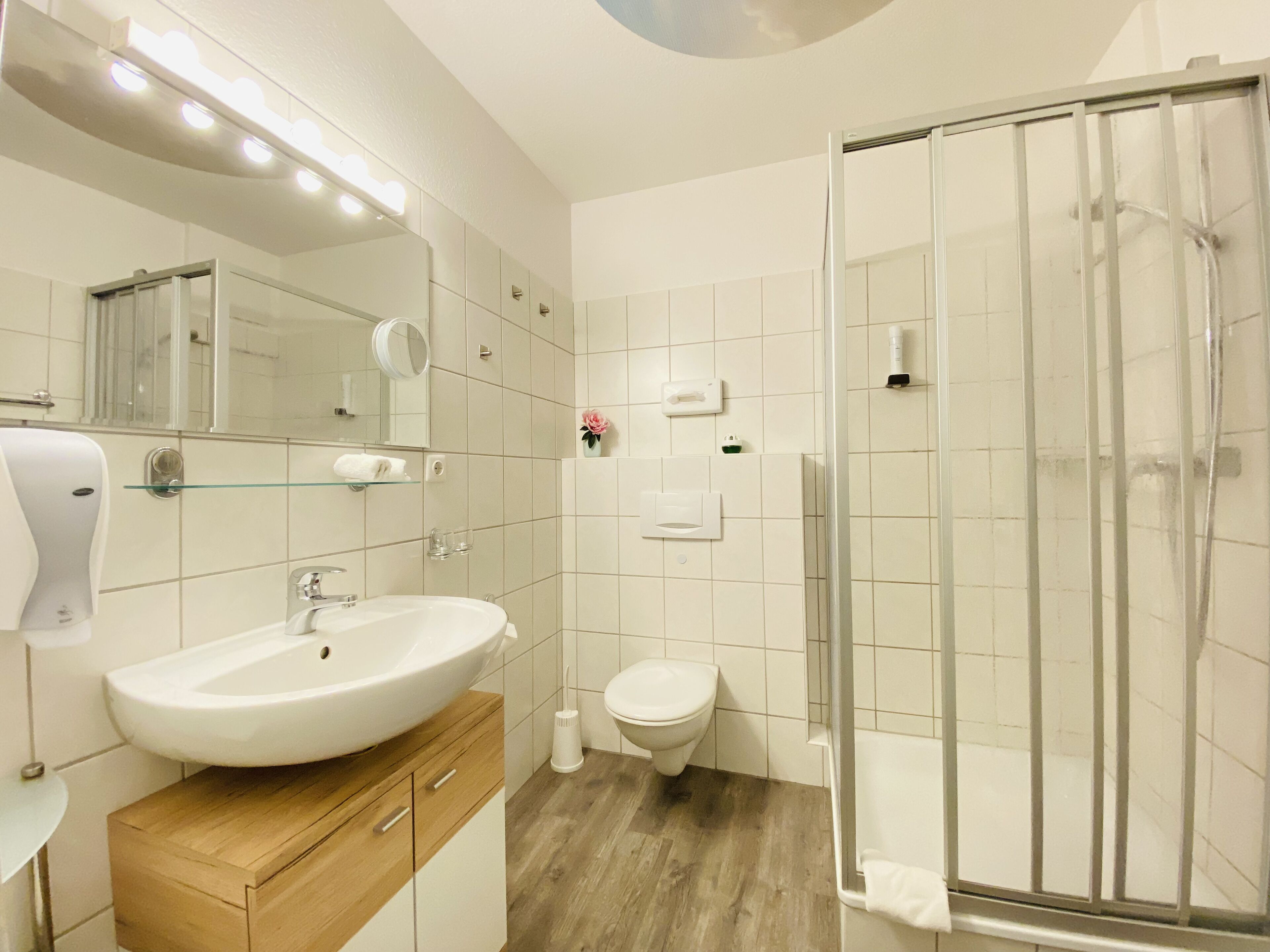 A modern bathroom with a large sink, a toilet, and a glass shower enclosure.