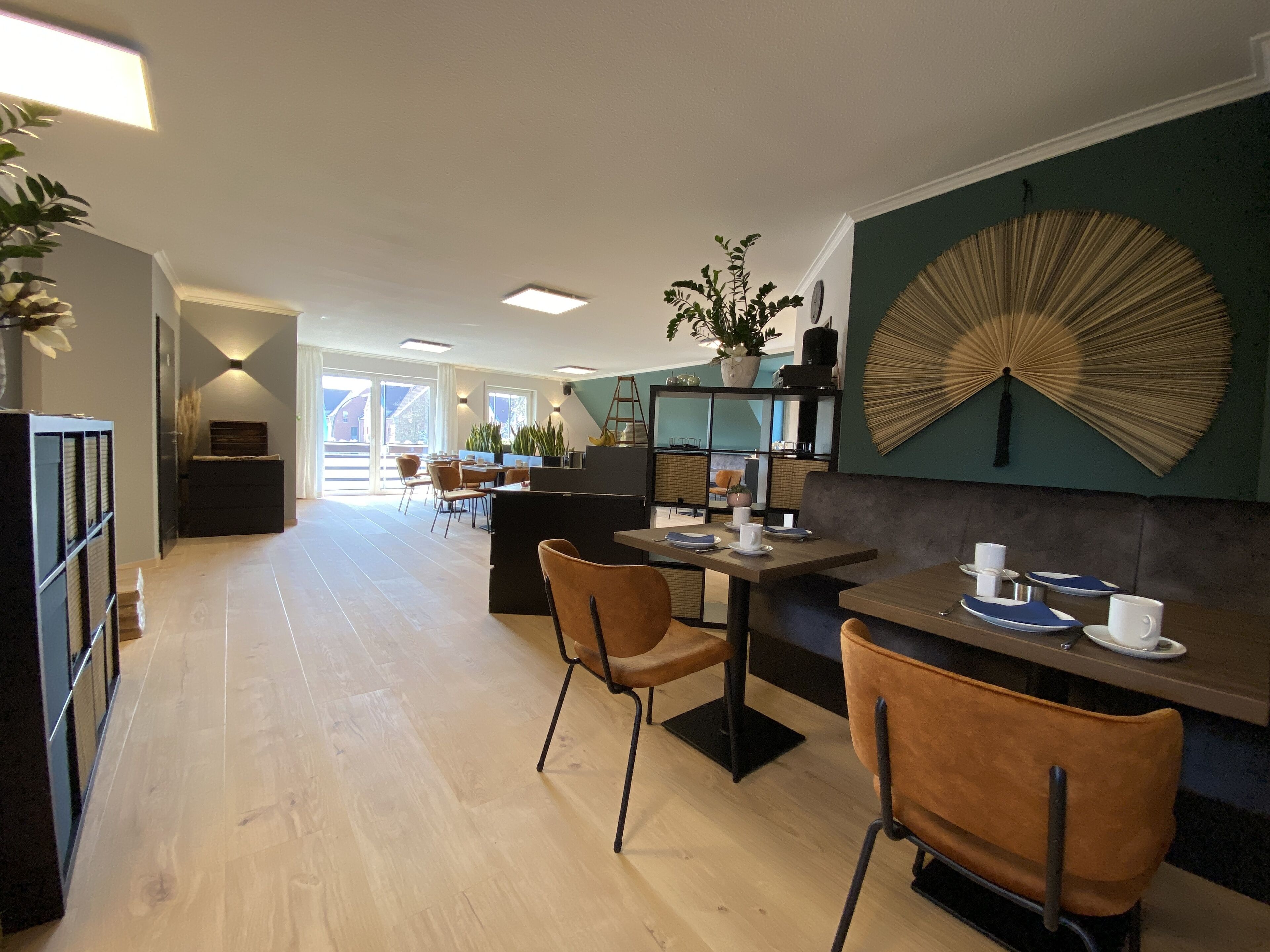 Een moderne keuken met een eethoek, met een grote ventilator, houten kastjes en uitzicht op de omgeving.