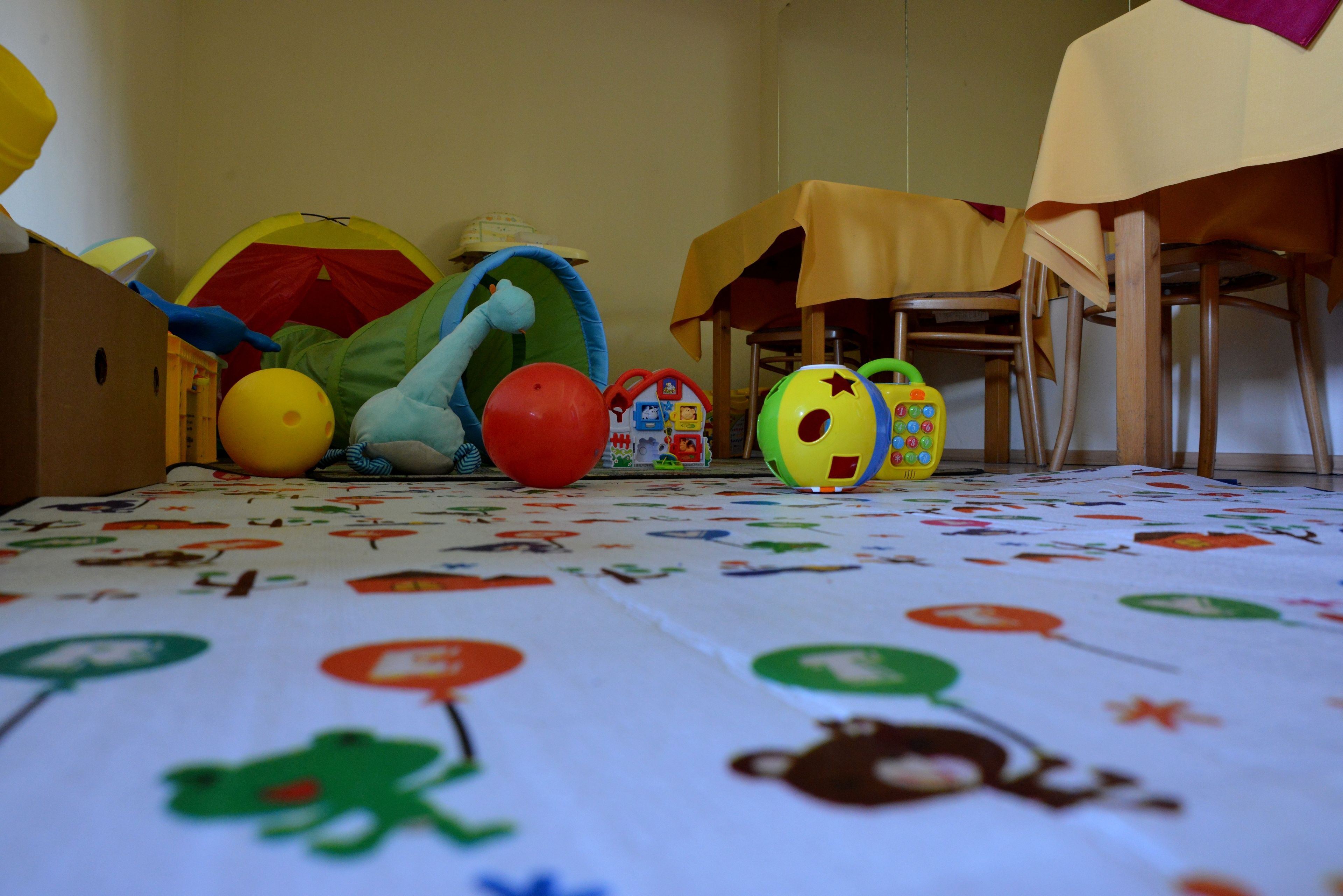 A room with a play area including a ball pit, toys, and a table with a tablecloth.