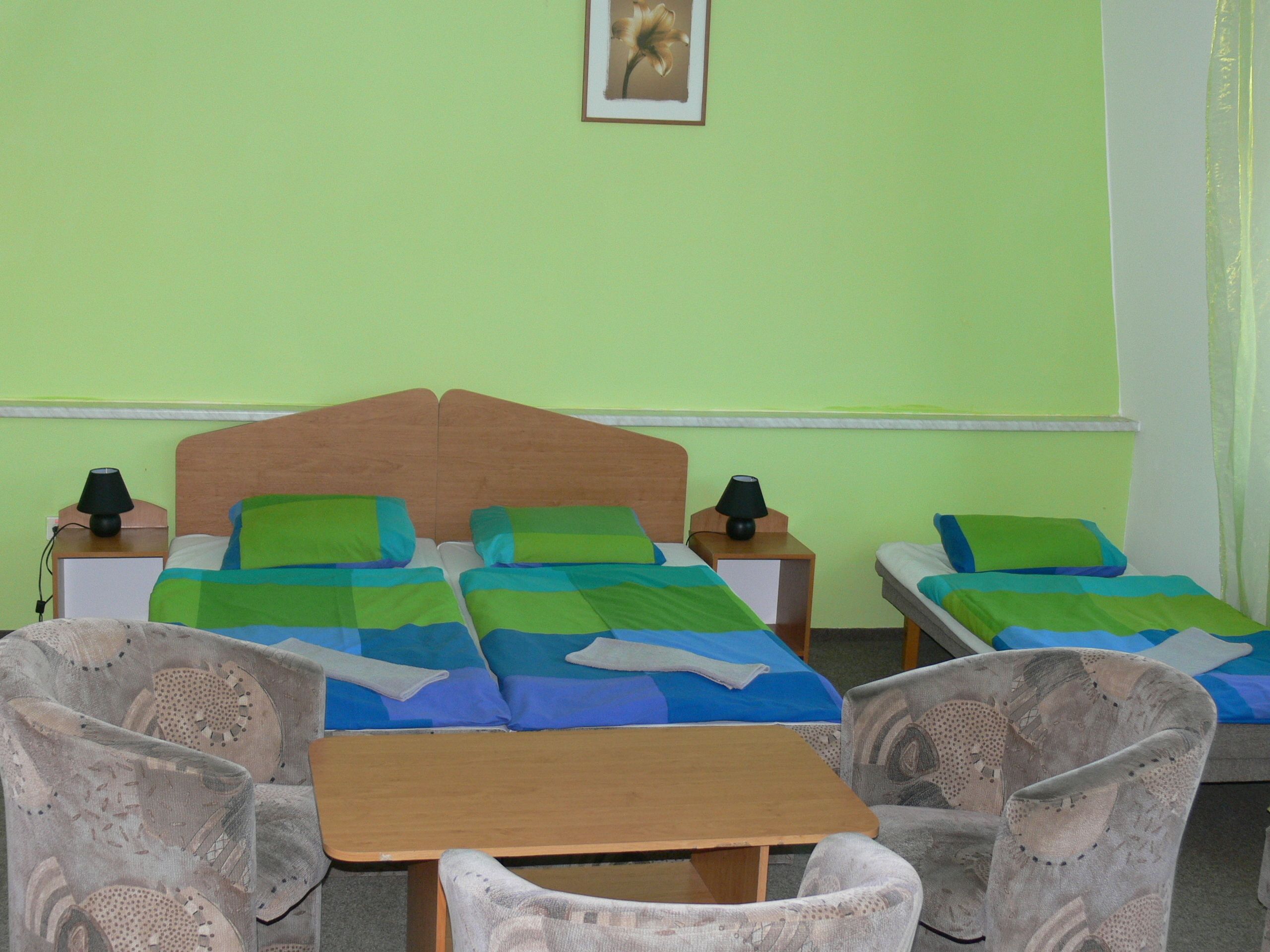 A room with two beds, a table, and two chairs.