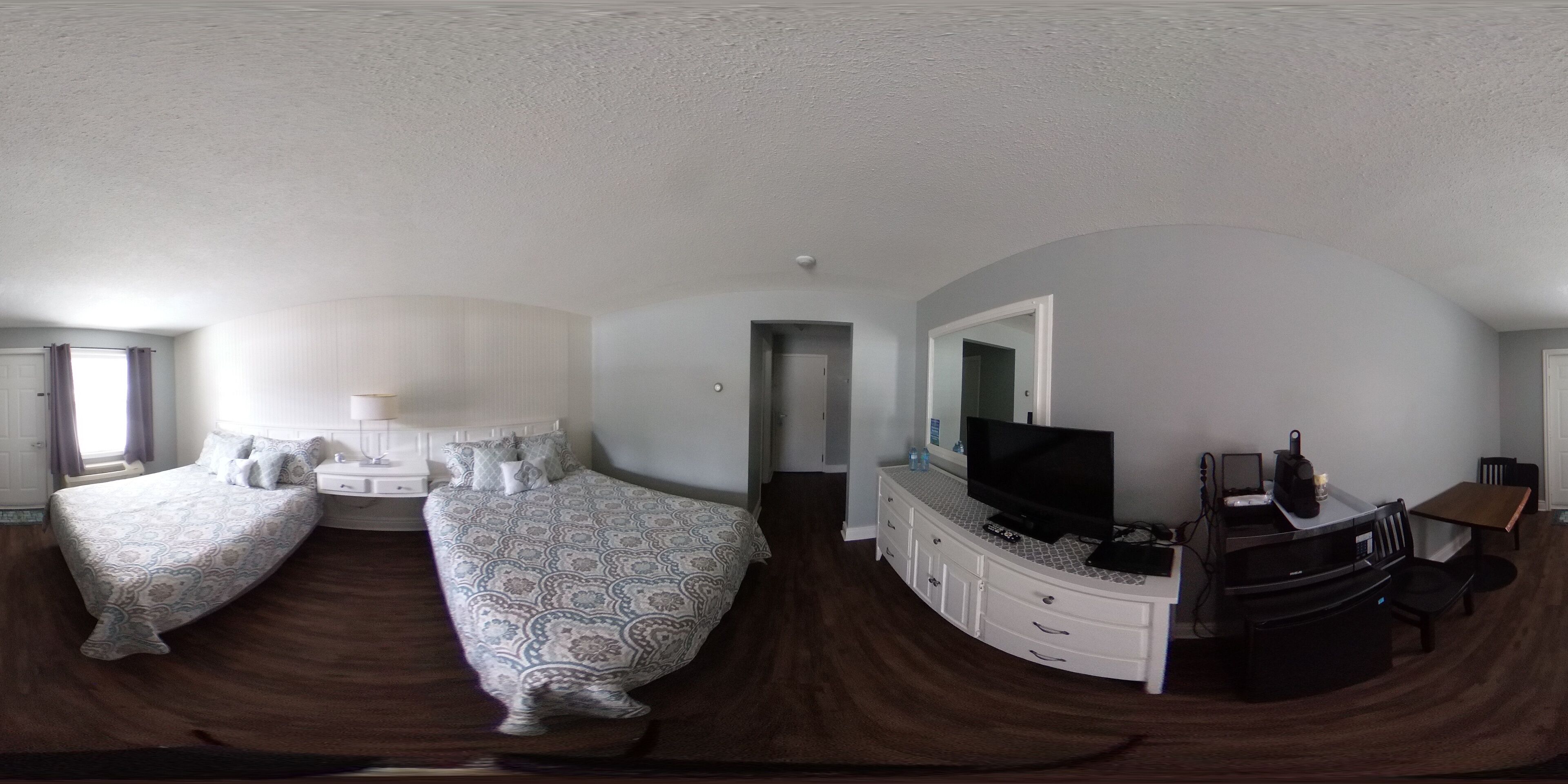 Un dormitorio con dos camas, televisión, escritorio y una silla.
