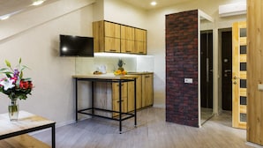 Una cocina moderna con armarios de madera, una pequeña isla y una pared decorada con ladrillos.