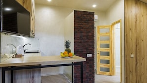 Una cocina moderna con encimera de madera, estufa integrada y frutero.