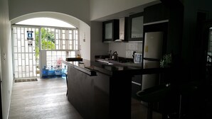 A modern kitchen with a central island, a refrigerator, and a microwave. - Hospedaje Solymar Islas (San Andrés)