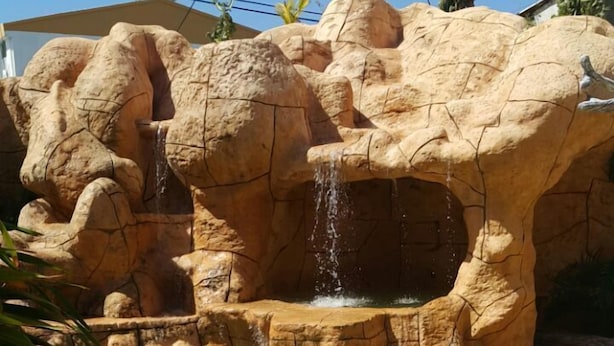A clear pool with a rocky waterfall feature. - Hospedaje Solymar Islas (San Andrés)