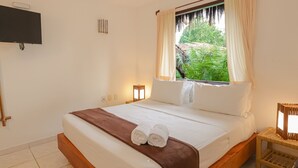 A hotel room with a large bed, a TV mounted on the wall, and a window with curtains. - Pousada Saudosa Maloca (Porto Seguro)