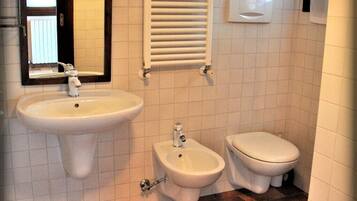 Ein Badezimmer mit Waschbecken, Bidet und Toilette.