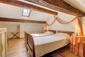 A bedroom with a wooden bed, a small table with a lamp, and a window with a view.