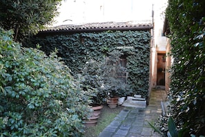 Escape to a serene courtyard surrounded by lush greenery and a traditional tiled roof.