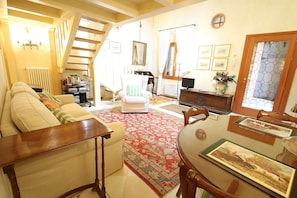 Relax in this inviting living space with a comfortable sofa, dining table, and ornate rug.