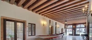 A spacious interior with a wooden ceiling, large windows, and a boat displayed against the wall.
